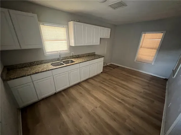 a large kitchen with granite countertop wooden cabinets a sink and a window