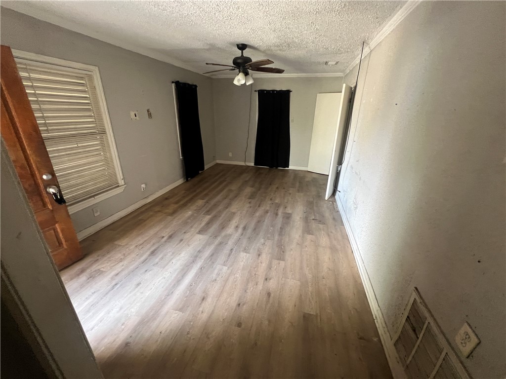 4031 West Vanderbilt Drive Corpus Christi, TX 78415 - Photo 4 of 9 a view of a room with wooden floor and a ceiling fan
