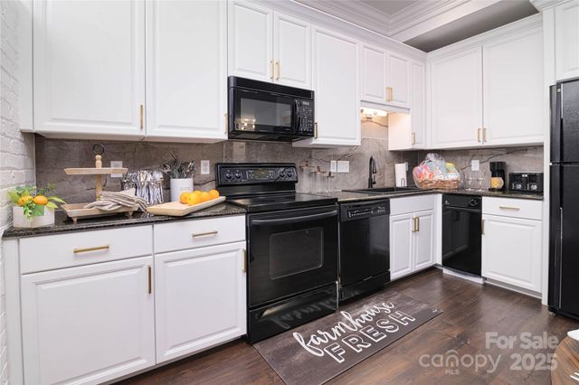 a kitchen with granite countertop white cabinets and white appliances