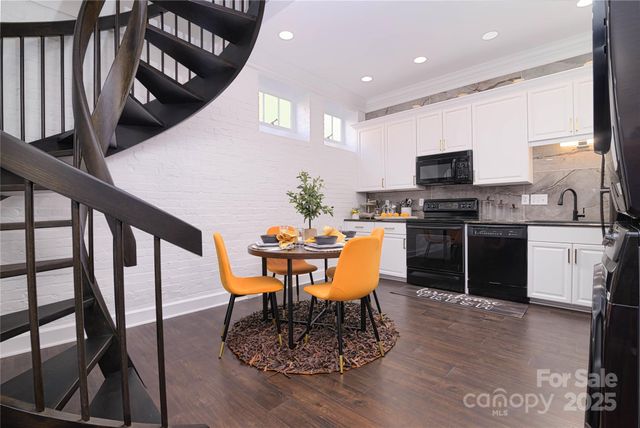 a kitchen with stainless steel appliances kitchen island granite countertop a stove a sink a microwave a dining table and chairs