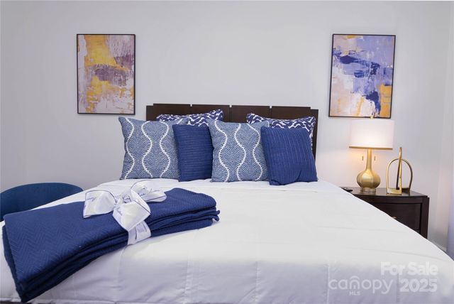 a bedroom with a bed and painting on the wall