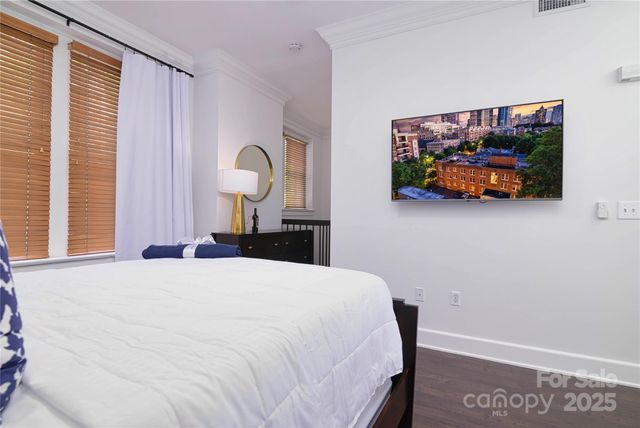 a bedroom with a bed and a painting on the wall