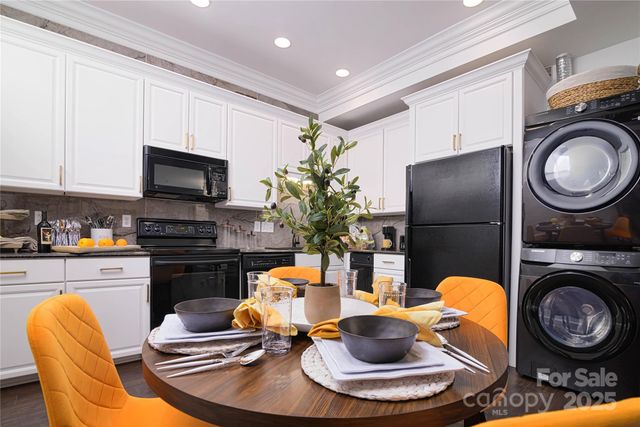 a kitchen with stainless steel appliances a dining table and chairs