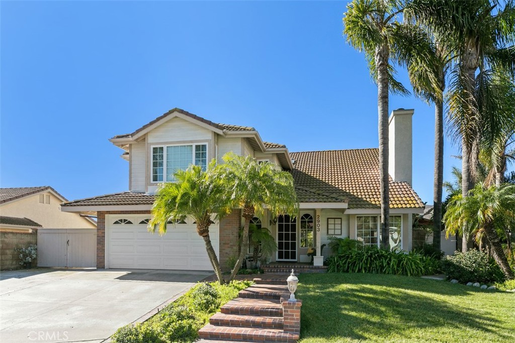 a front view of a house with a yard and potted plants