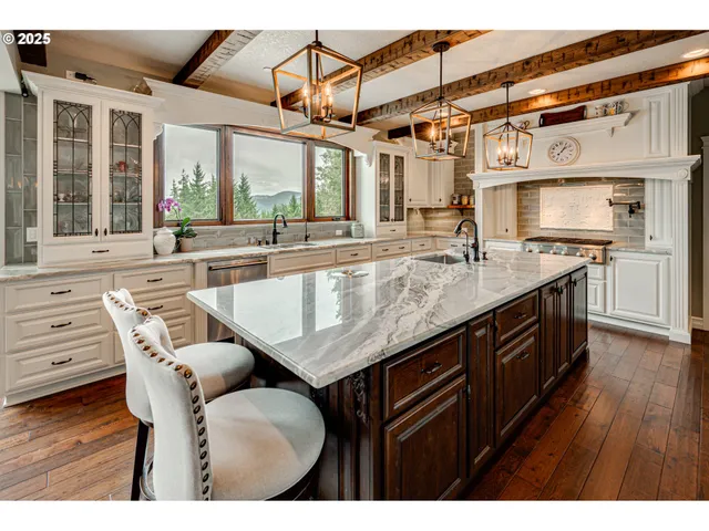 a kitchen with kitchen island granite countertop a table chairs in it and wooden floors