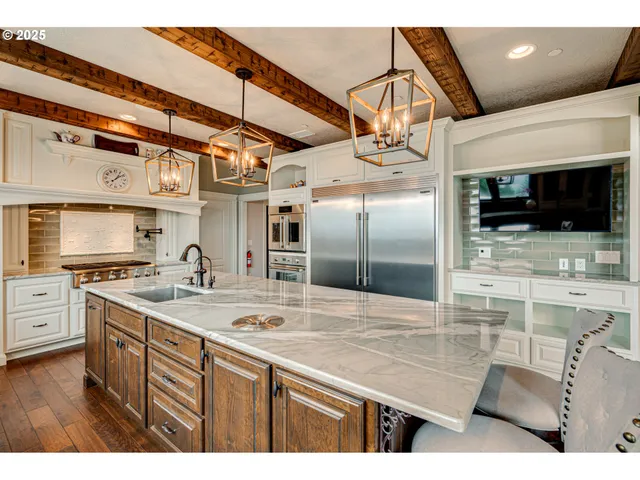 a kitchen with stainless steel appliances granite countertop a sink a stove and a refrigerator