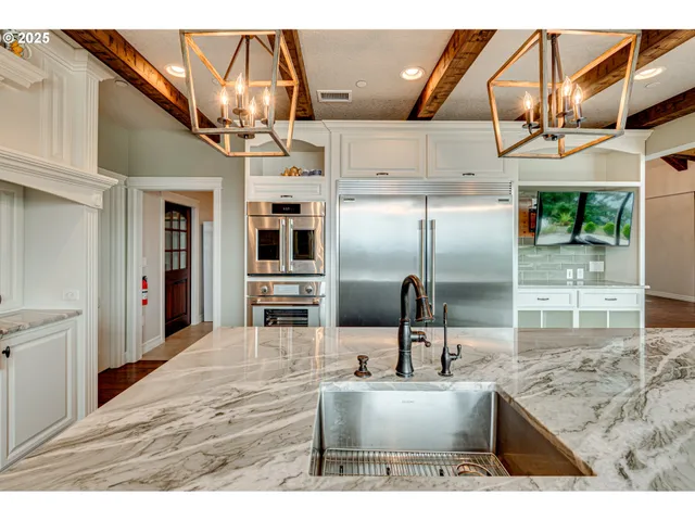 a kitchen with stainless steel appliances granite countertop a sink and a refrigerator