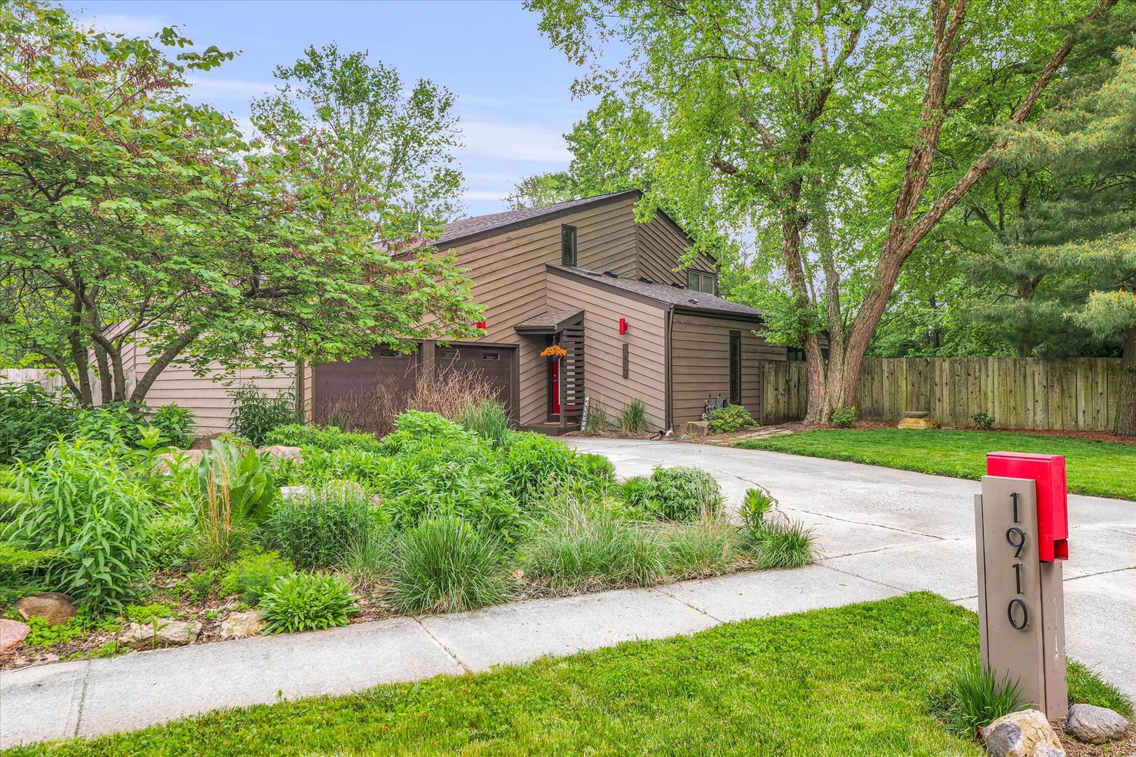 a front view of a house with a yard and a garden