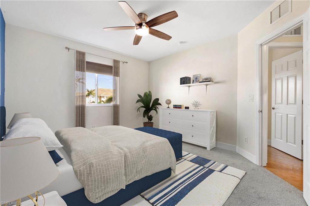 17560 Cherry Ridge Lane Fort Myers, FL 33967 - Photo 20 of 30 a bedroom with a large bed and a chandelier