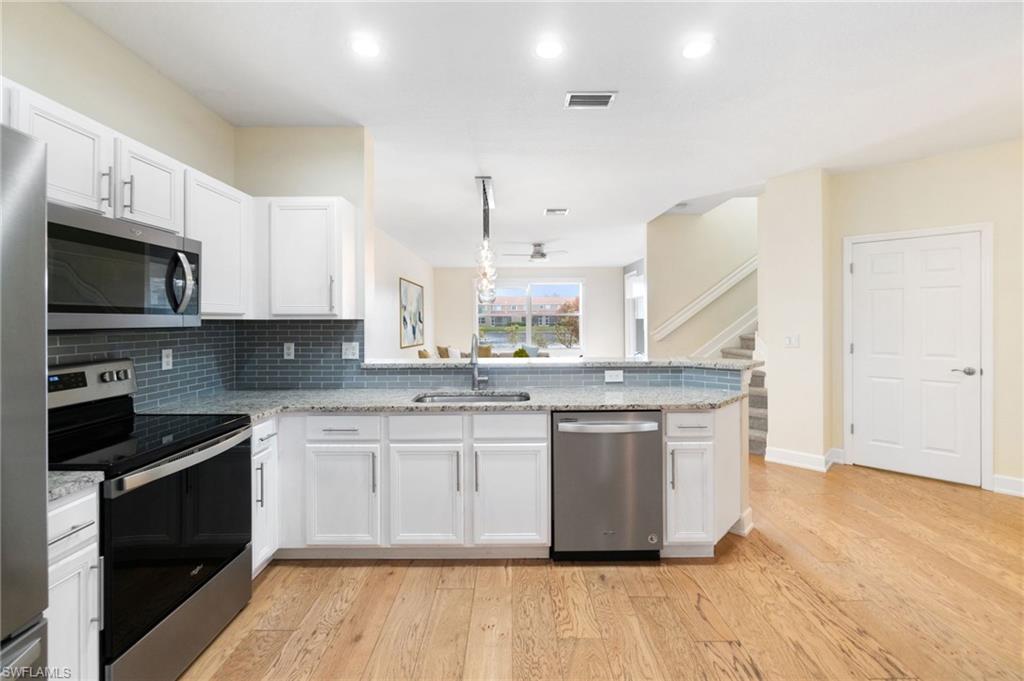 17560 Cherry Ridge Lane Fort Myers, FL 33967 - Photo 5 of 30 a kitchen with stainless steel appliances granite countertop a stove a sink and a microwave