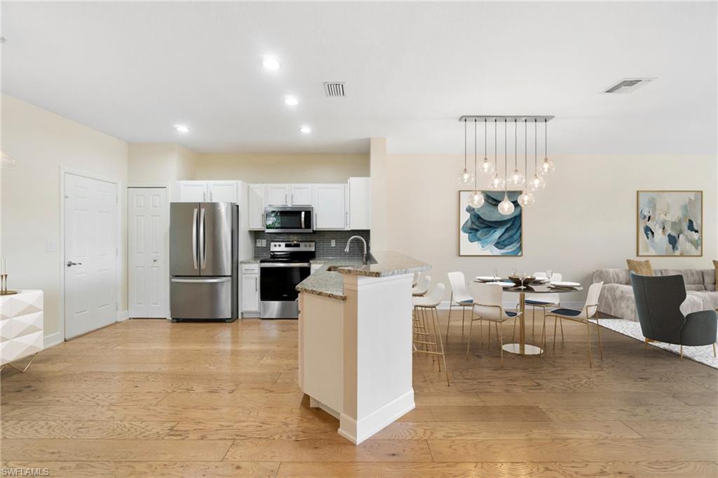 17560 Cherry Ridge Lane Fort Myers, FL 33967 - Photo 6 of 30 a kitchen with stainless steel appliances kitchen island granite countertop a refrigerator and cabinets