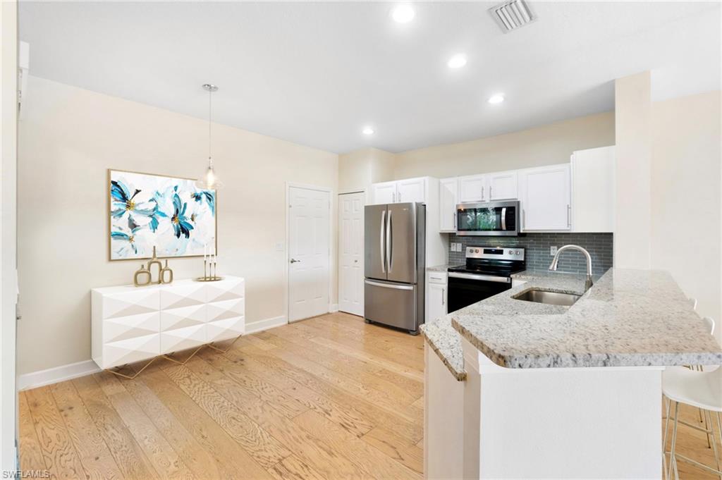 17560 Cherry Ridge Lane Fort Myers, FL 33967 - Photo 7 of 30 a kitchen with kitchen island a refrigerator sink and stove