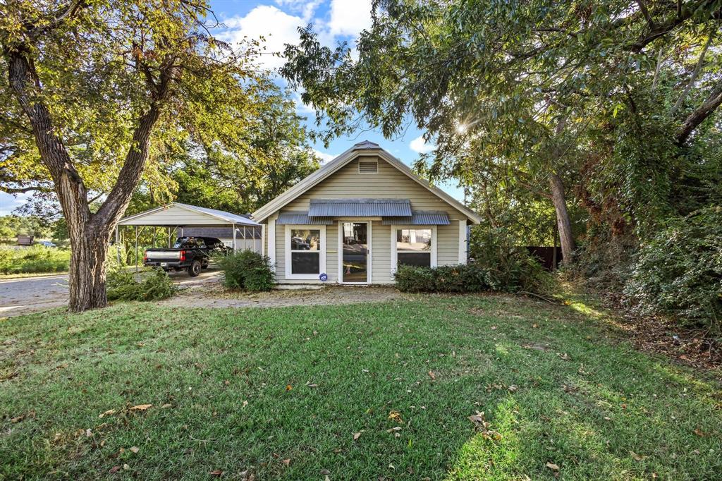 a front view of a house with a yard and trees
