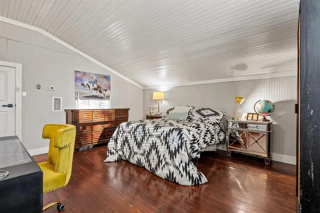 a bedroom with bed and wooden floor