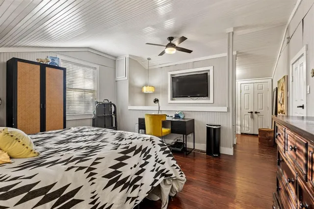 a bedroom with a bed window and a flat screen tv