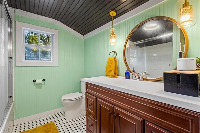 a bathroom with a sink a toilet and mirror