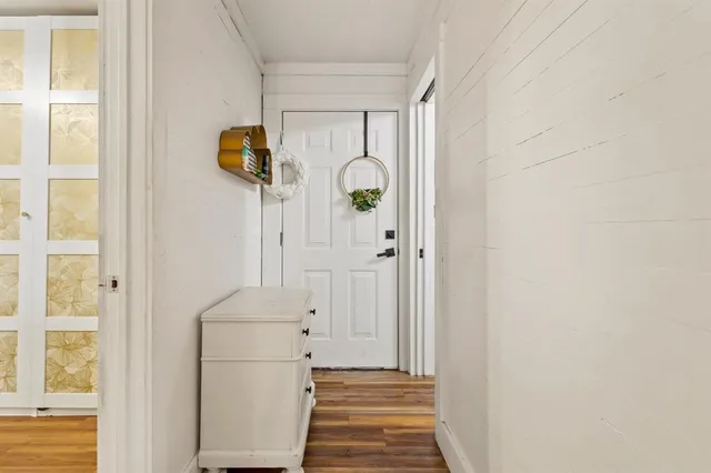 a view of a hallway with wooden floor and entryway