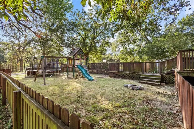a view of a backyard with wooden fence and a bench
