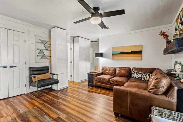 a living room with furniture and a wooden floor