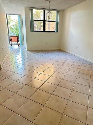 an empty room with windows and chandelier
