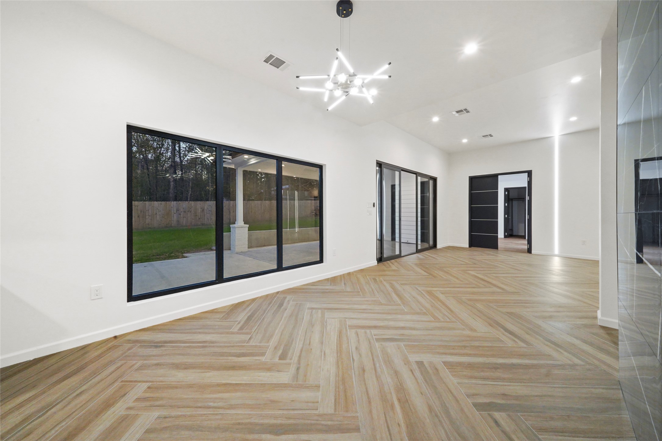 2438 Carriage Lamp Lane Conroe, TX 77384 - Photo 18 of 41 a view of an empty room with a chandelier fan and windows