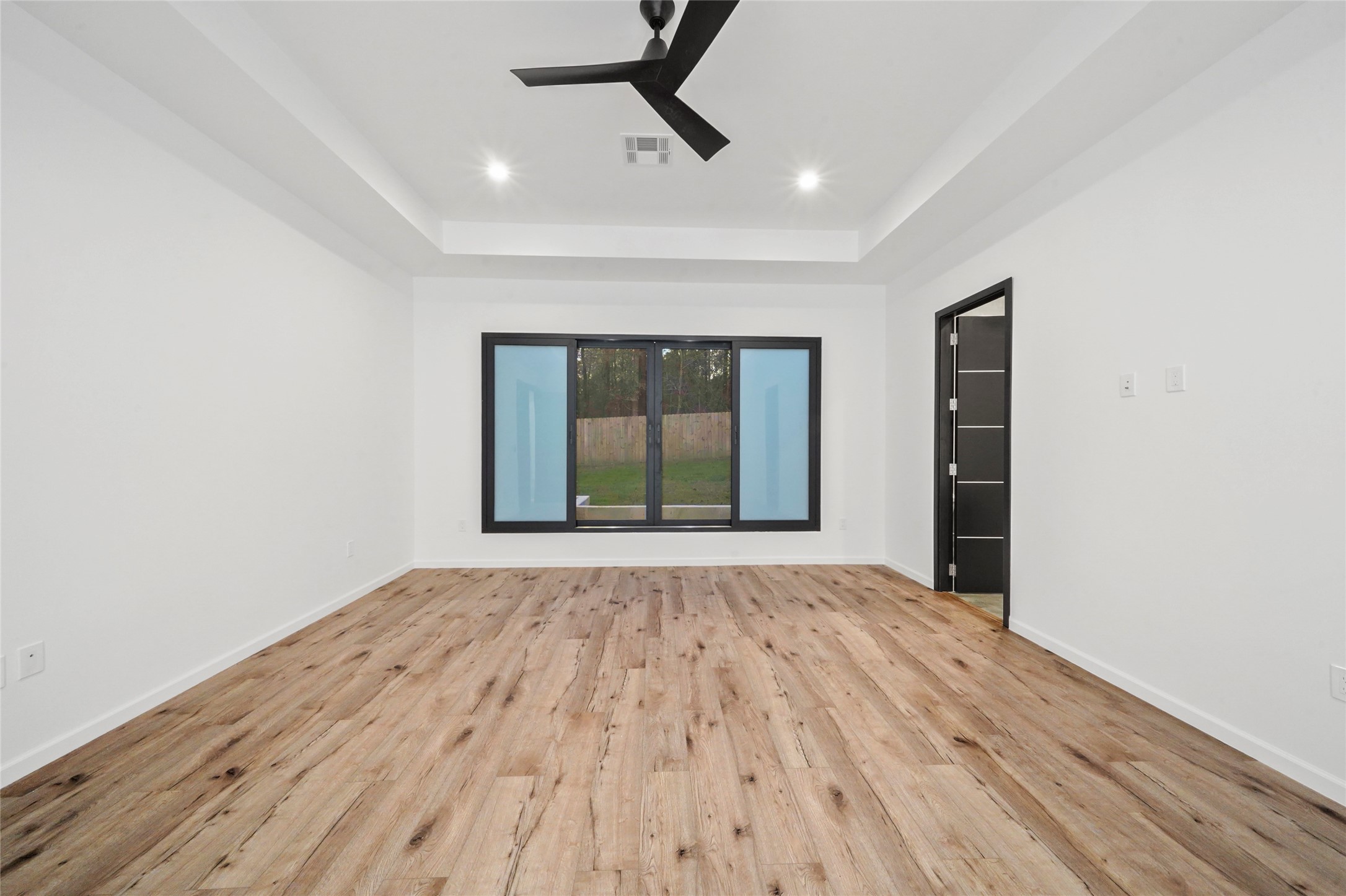 2438 Carriage Lamp Lane Conroe, TX 77384 - Photo 20 of 41 a view of an empty room with wooden floor and a window
