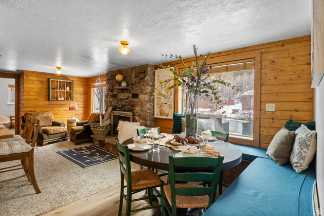 2189 Samak Park Loop, Unit 43 Kamas, UT 84036 - Photo 16 of 48 Dining space featuring wooden walls, a textured ceiling, a fireplace, and wood finished floors
