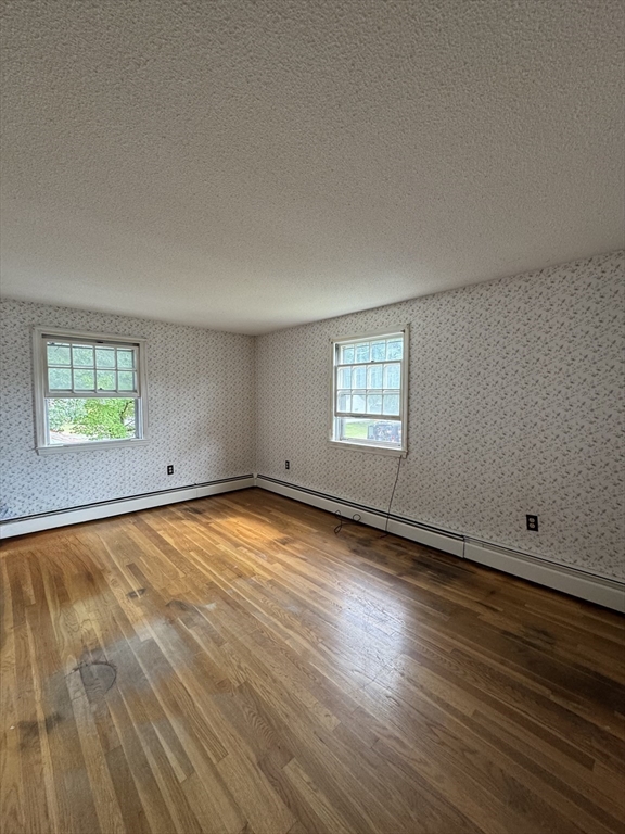 9 Edgewood Avenue Merrimack, NH 03054 - Photo 11 of 13 an empty room with wooden floor and windows