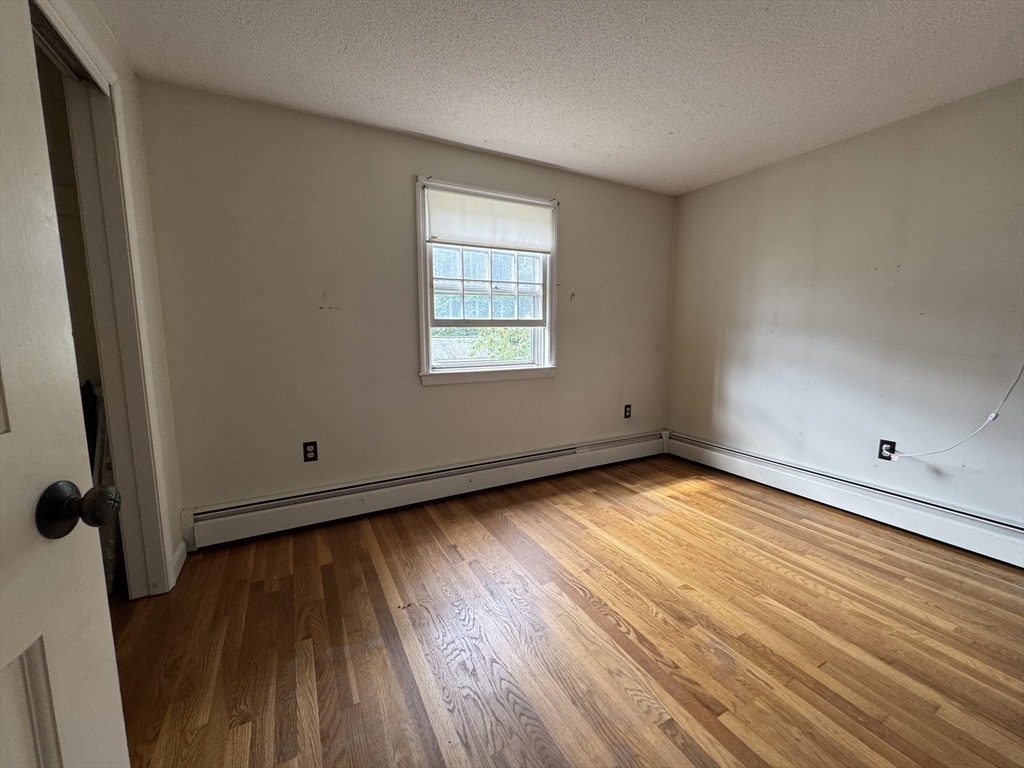 9 Edgewood Avenue Merrimack, NH 03054 - Photo 9 of 13 an empty room with wooden floor and windows