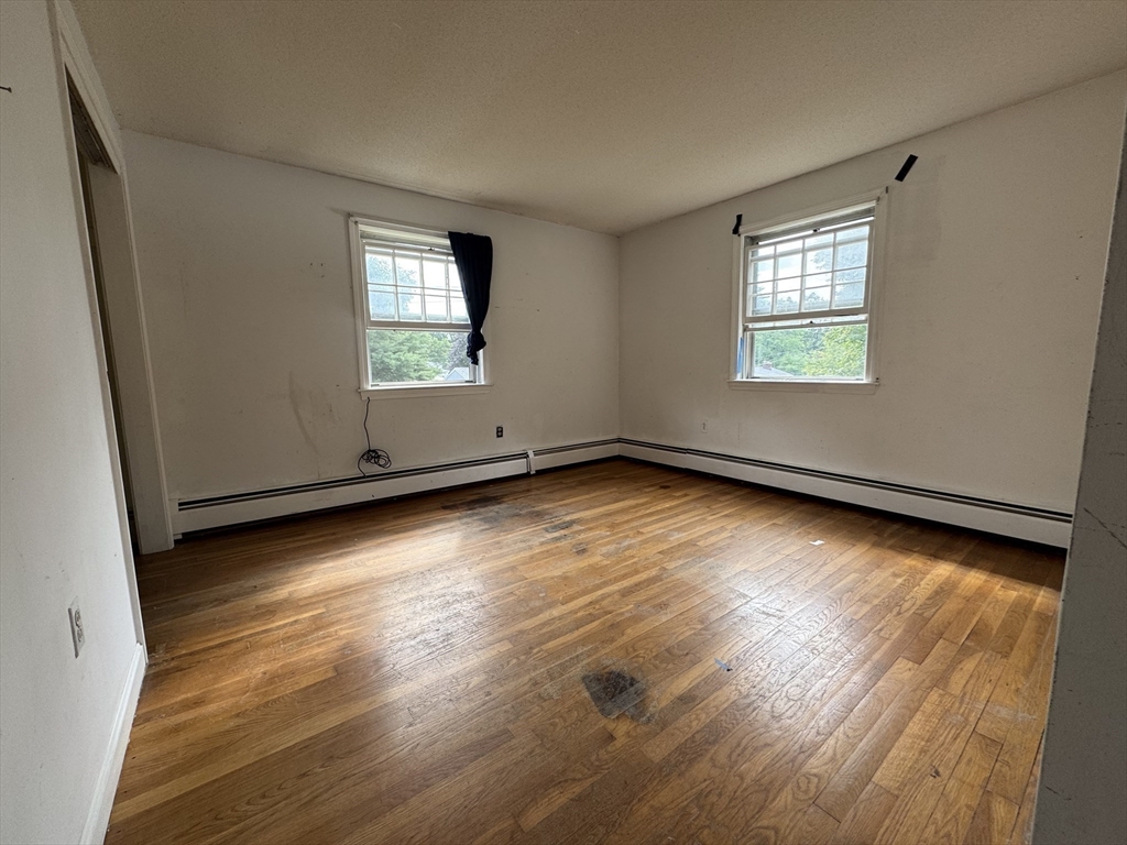 9 Edgewood Avenue Merrimack, NH 03054 - Photo 10 of 13 an empty room with wooden floor and windows