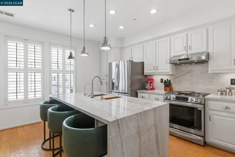 a kitchen with kitchen island granite countertop a sink stainless steel appliances and cabinets