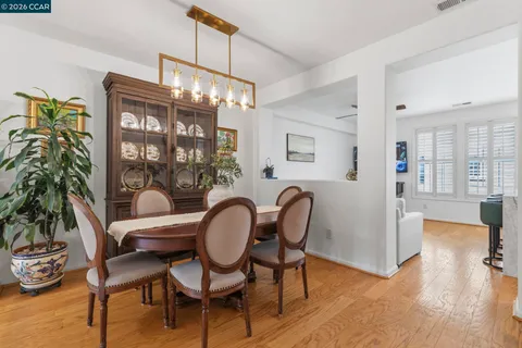 a view of a dining room with furniture a chandelier and wooden floor