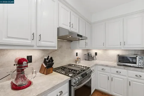 a kitchen with white cabinets and sink