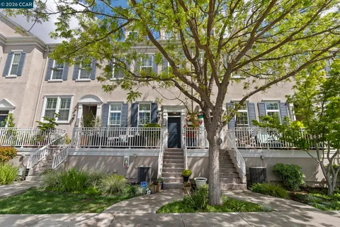 a front view of a house with a tree