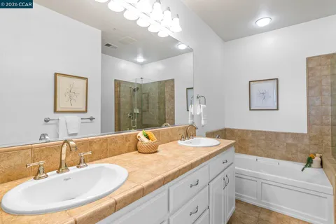 a bathroom with a granite countertop sink mirror and bathtub