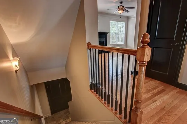 a view of a hallway with wooden floor and staircase