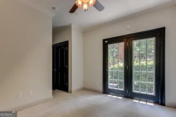 a big room with windows and a chandelier fan