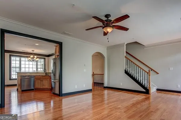 a view of a livingroom with a ceiling fan and wooden floor