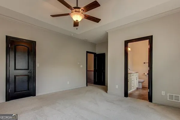 an empty room with closet and a chandelier fan