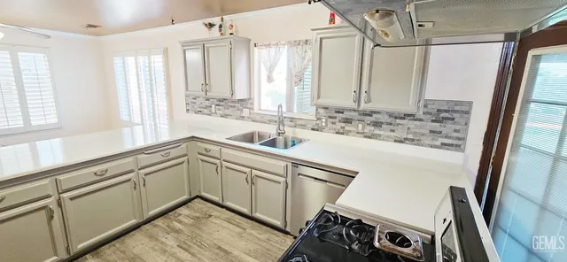 a kitchen with granite countertop a sink stove and cabinets