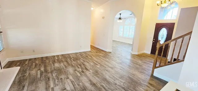 a view of a hallway with wooden floor and a bathroom