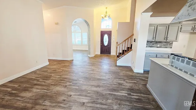 an empty room with wooden floor and a bathroom view