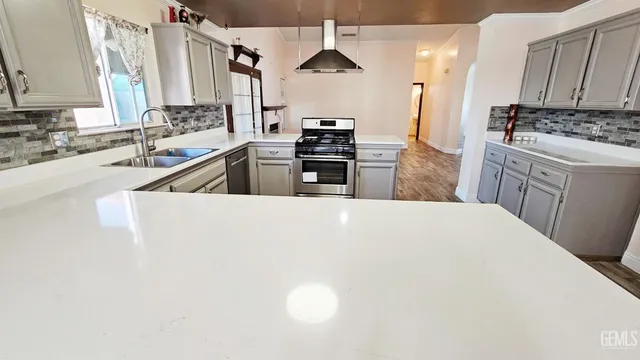 a kitchen with stainless steel appliances a stove a sink a microwave and cabinets