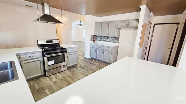a kitchen with granite countertop a sink stove and refrigerator