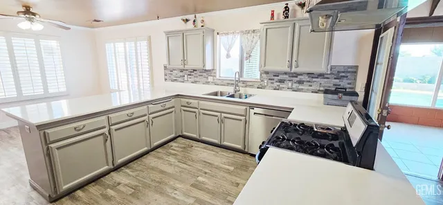 a kitchen with granite countertop a sink stove and refrigerator