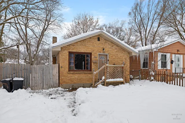 a front view of a house with a yard covered in snow