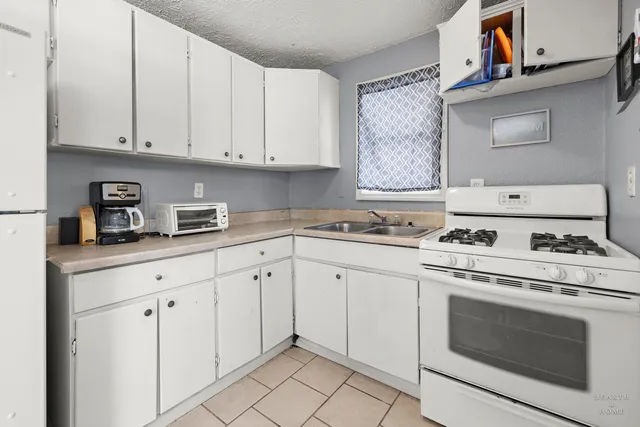 a kitchen with white cabinets and white appliances
