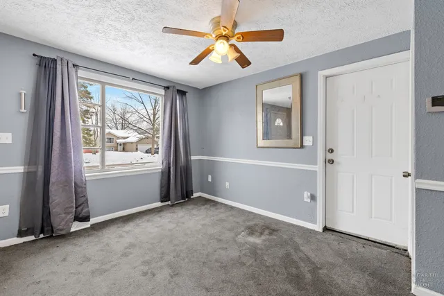 a view of an empty room with window and closet area