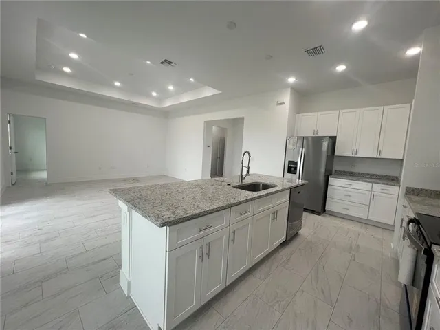 a kitchen with stainless steel appliances granite countertop a sink and a stove top oven