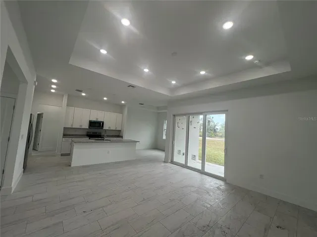 a view of a hall with kitchen and living room